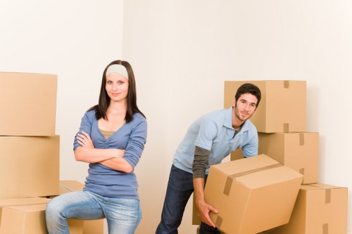 Removal van and movers handling furniture on a residential Kingsbury street